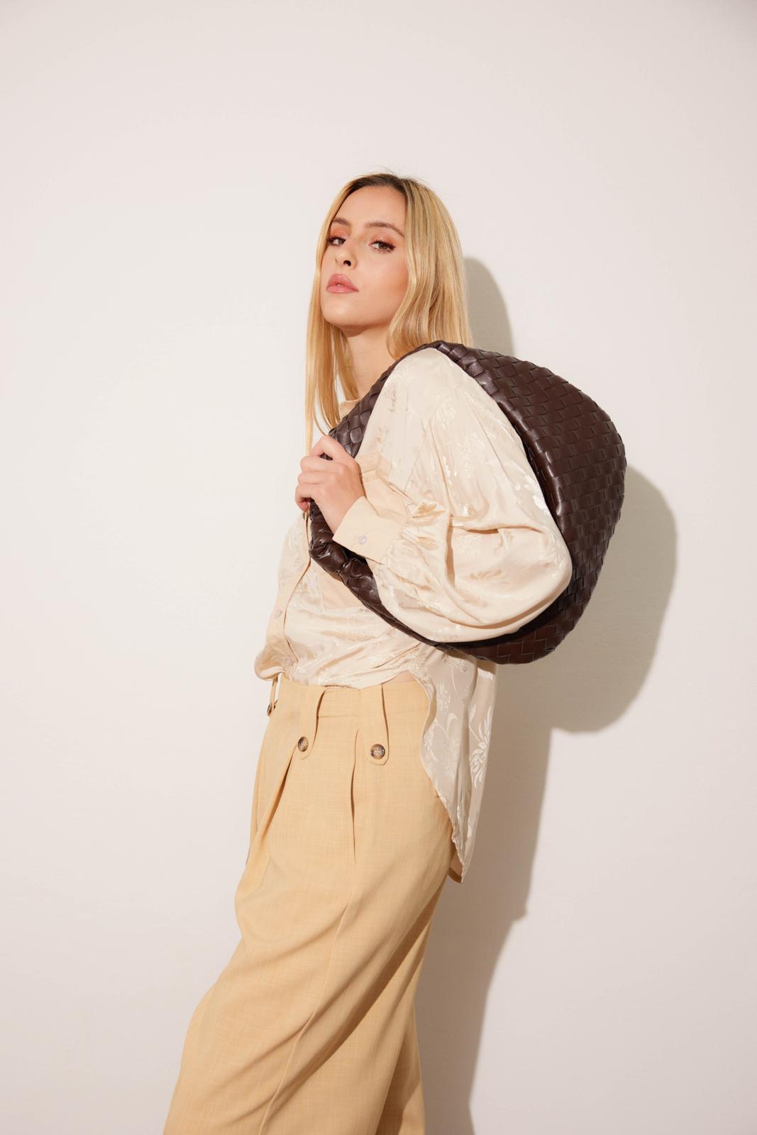 Camicia in raso color crema con pantaloni beige e borsa marrone a spalla